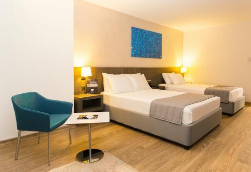 a hotel room with two beds and a chair at Fesa Business Hotel in Gebze
