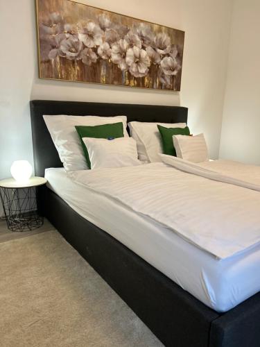 a large bed with white and green pillows at West Budapest-Edge of Downtown-Free Parking in Budapest