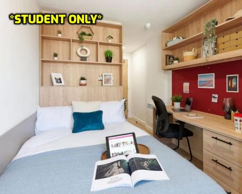 a bedroom with a bed and a desk with a book at Student Only Ensuite Rooms Zeni Bournemouth in Bournemouth
