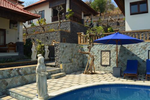 a pool with a statue next to a house at Shankara Parada Villas in Amed