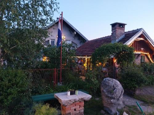 une maison avec un banc en pierre devant elle dans l'établissement Apartment Ada bed & breakfast, à Gračac