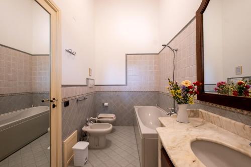 a bathroom with a tub and a toilet and a sink at Tenuta Il Carretto in Monteroni di Lecce