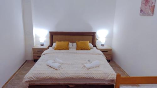 a bedroom with a bed with two white shoes on it at Apartman Kutak in Pirot