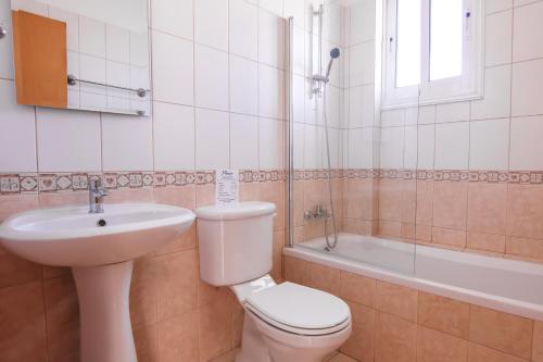 a bathroom with a toilet and a sink and a tub at Phaedrus Living: Universal City Flat Alina in Paphos City