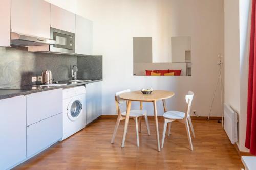 une cuisine avec une table et des chaises dans une pièce dans l'établissement Studio Near Place Massena, à Nice