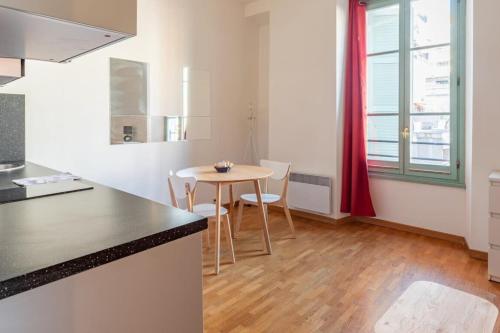 une cuisine avec une table et des chaises dans une pièce dans l'établissement Studio Near Place Massena, à Nice
