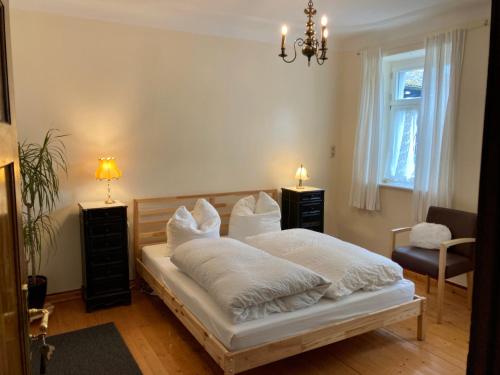 um quarto com uma cama com lençóis brancos e almofadas em Hinkelshof em Körperich