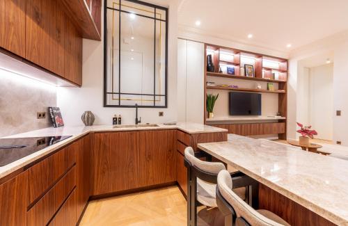 a kitchen with wooden cabinets and a large island at LuxueuseSuite - TourEiffel (Flandrin/Muette) - AC in Paris