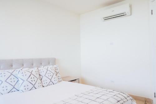 a bedroom with a bed and a white wall at Oceanview Apt Near Panama City w/ King Bed & More in Playa Bonita Village