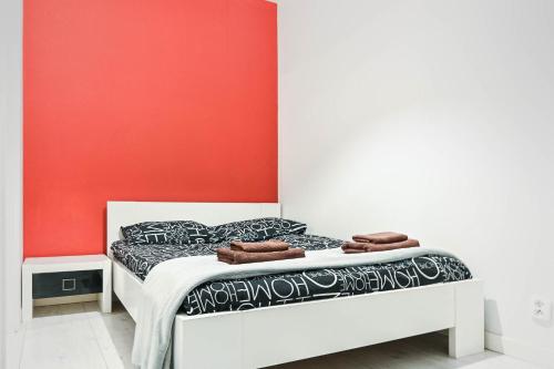 łóżko w pokoju z czerwoną ścianą w obiekcie D&A Apartments Old Town w Krakowie