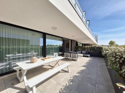 a patio with two benches on the side of a house at Duinhof in Cadzand-Bad