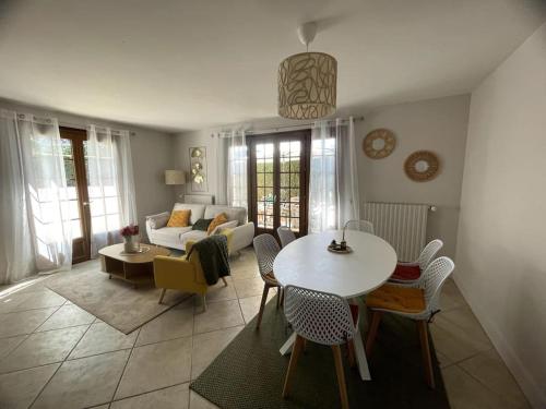 un soggiorno con un tavolo e un divano di Maison 6 couchages, 200m plage a Bénerville-sur-Mer