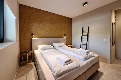 a bedroom with a large bed with towels on it at Duinhof in Cadzand-Bad