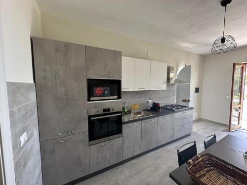 a kitchen with stainless steel appliances and a dining table at Le Case di Concetta in Santa Maria