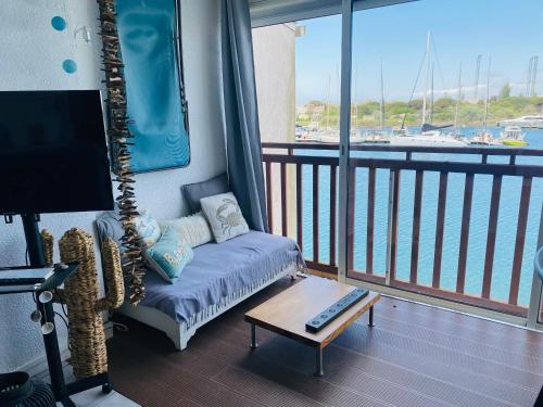 un salon avec un canapé et une vue sur l'eau dans l'établissement La Brigantine - Superbe vue mer - Appartement agréable en toutes saisons, au Cap d'Agde