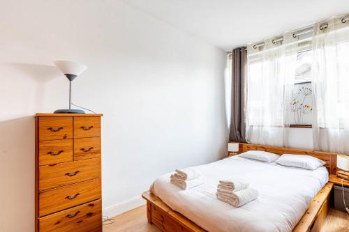 une chambre avec un lit, une commode et une fenêtre dans l'établissement GuestReady - A marvellous city retreat, à Paris