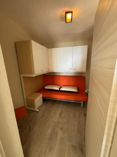 a small room with a red bed and white cabinets at Le Case di Concetta in Santa Maria