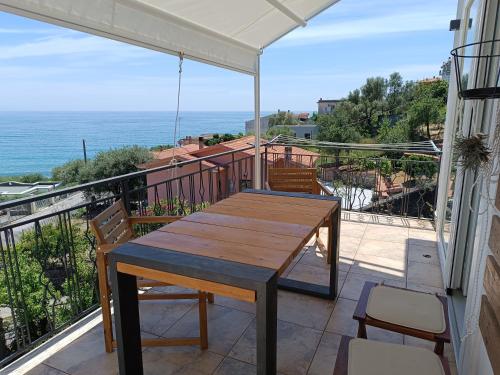 einen Holztisch auf einem Balkon mit Meerblick in der Unterkunft Casa Vittoria trilocale in Villammare