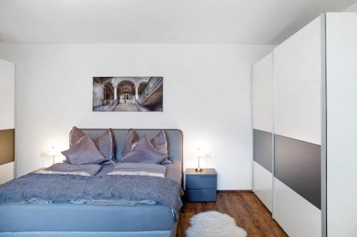 a bedroom with a blue bed and a mirror at Mosers Ferienwohnung am Sonnenhang in Jenbach