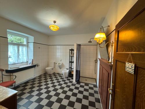 uma casa de banho com piso em xadrez preto e branco em Hinkelshof em Körperich