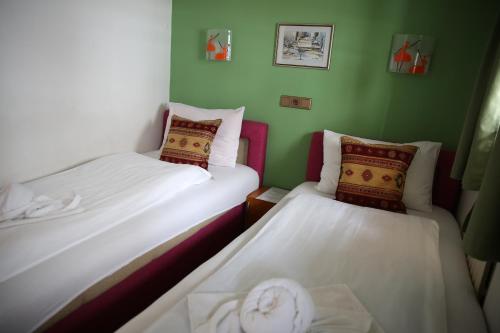 2 camas en una habitación pequeña con paredes verdes en Guesthouse Yildiz 2 en Sarajevo