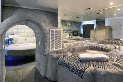 The Sage Hotel في Muscatine: غرفة نوم بحمام كبير مع حوض استحمام وسرير