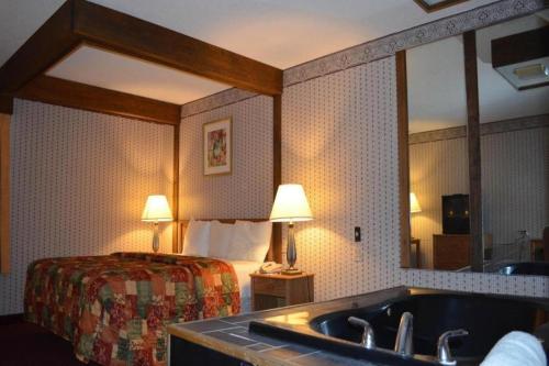 The Sage Hotel في Muscatine: حمام مع سرير ومغسلة في غرفة الفندق