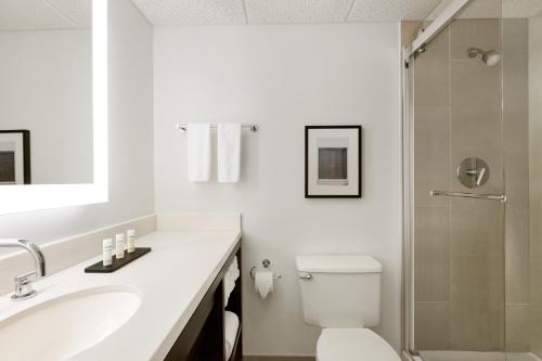 布卡拉顿Cozy Two Room Suite with Modern Touches and Pool的配有马桶、水槽和淋浴的浴室