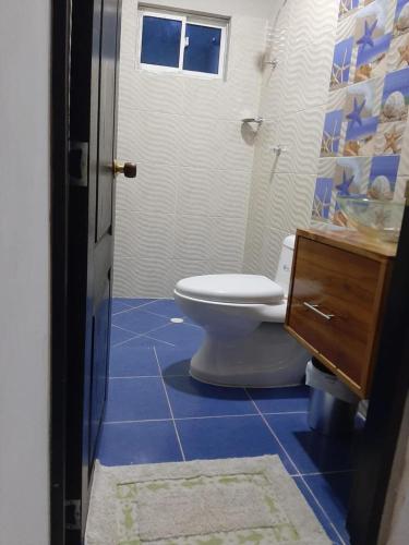 a bathroom with a toilet and a blue tile floor at Rutymar crab in Necoclí