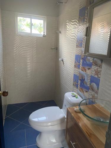 a bathroom with a toilet and a sink and a window at Rutymar crab in Necoclí