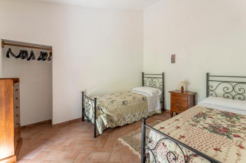 a bedroom with two beds and a dresser in it at Podere Marcigliana in Radicondoli