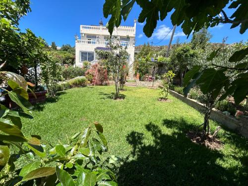 a garden with trees and a building in the background at La Perla Montaña Tanger in Tangier