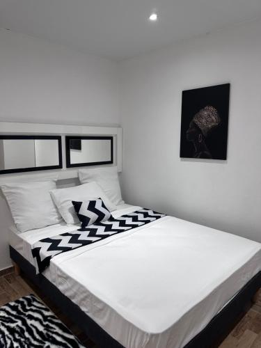 a bedroom with a large bed with black and white sheets at A MO TI KOTE in Guenouillet