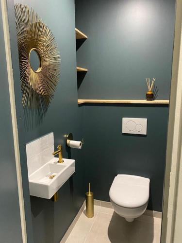 une salle de bain avec des toilettes blanches et un lavabo dans l'établissement Chez Alexine, à Reims