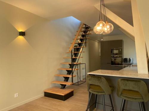 un escalier en colimaçon dans une cuisine avec un comptoir et des tabourets dans l'établissement Chez Alexine, à Reims