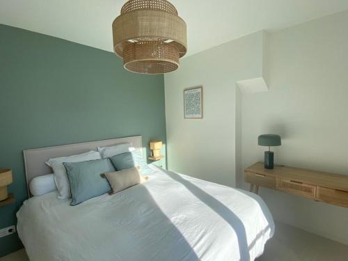 une chambre avec un grand lit blanc avec des oreillers bleus dans l'établissement Chez Alexine, à Reims