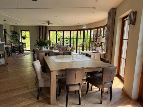 uma sala de jantar com uma mesa de madeira e cadeiras em Bed&Breakfast hotel de Greune Weide em Eibergen