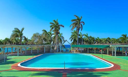een groot zwembad in een resort met palmbomen bij Palm JA SCA31 - Relaxing 1 BR with Beach & Pool Access in Montego Bay