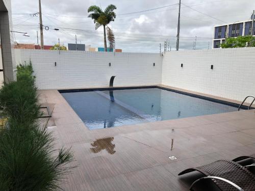 una piscina frente a una pared blanca en Apartamento para São João en Campina Grande