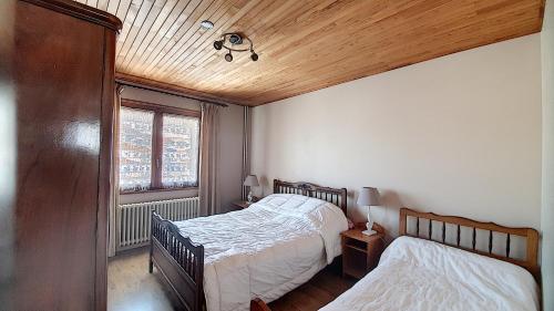 une chambre avec deux lits et une fenêtre dans l'établissement Grand Vane 4, à Morzine