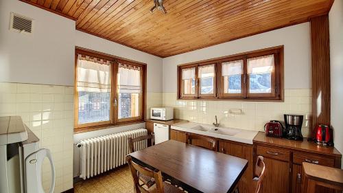 Il comprend une cuisine avec une table et un plafond en bois. dans l'établissement Grand Vane 4, à Morzine
