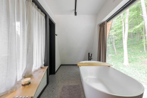 a bathroom with a tub and a large window at Time ForRest in Maidan Village