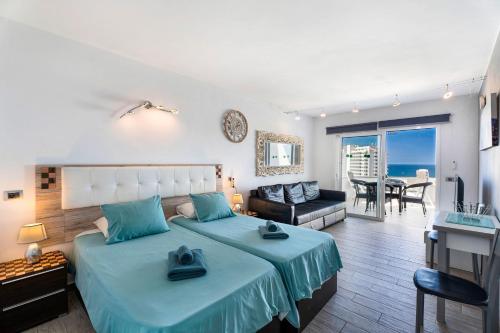 a bedroom with a large bed and a living room at Las Flores 407 in Playa Fañabe