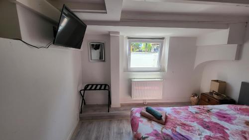 a bedroom with a bed and a television on the wall at BnB Souterrain in Amsterdam