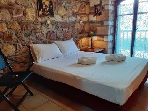 a bedroom with a large bed with two towels on it at Nerotrivia stone house in Nerotriviá