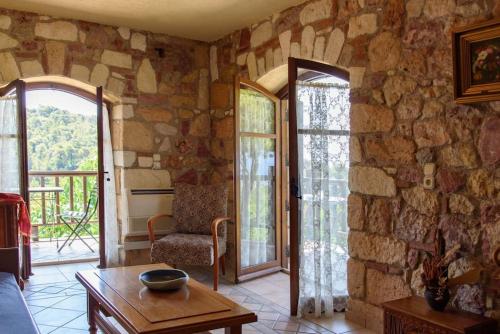 a living room with a stone wall and two doors at Nerotrivia stone house in Nerotriviá