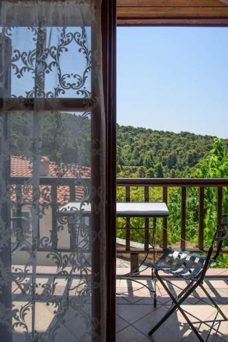 a window with a chair and a table on a balcony at Nerotrivia stone house in Nerotriviá