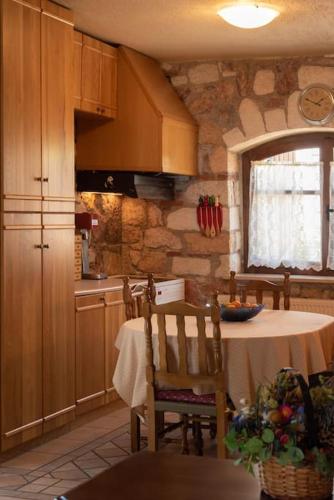 a kitchen with a table and a kitchen with a stone wall at Nerotrivia stone house in Nerotriviá