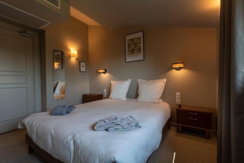 a bedroom with a bed with a robe on it at Hôtel du DOMAINE SAINT LOUP in Michelbach