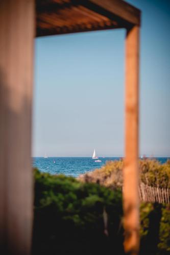 a window view of the ocean with a sail boat at Salines in Hyères